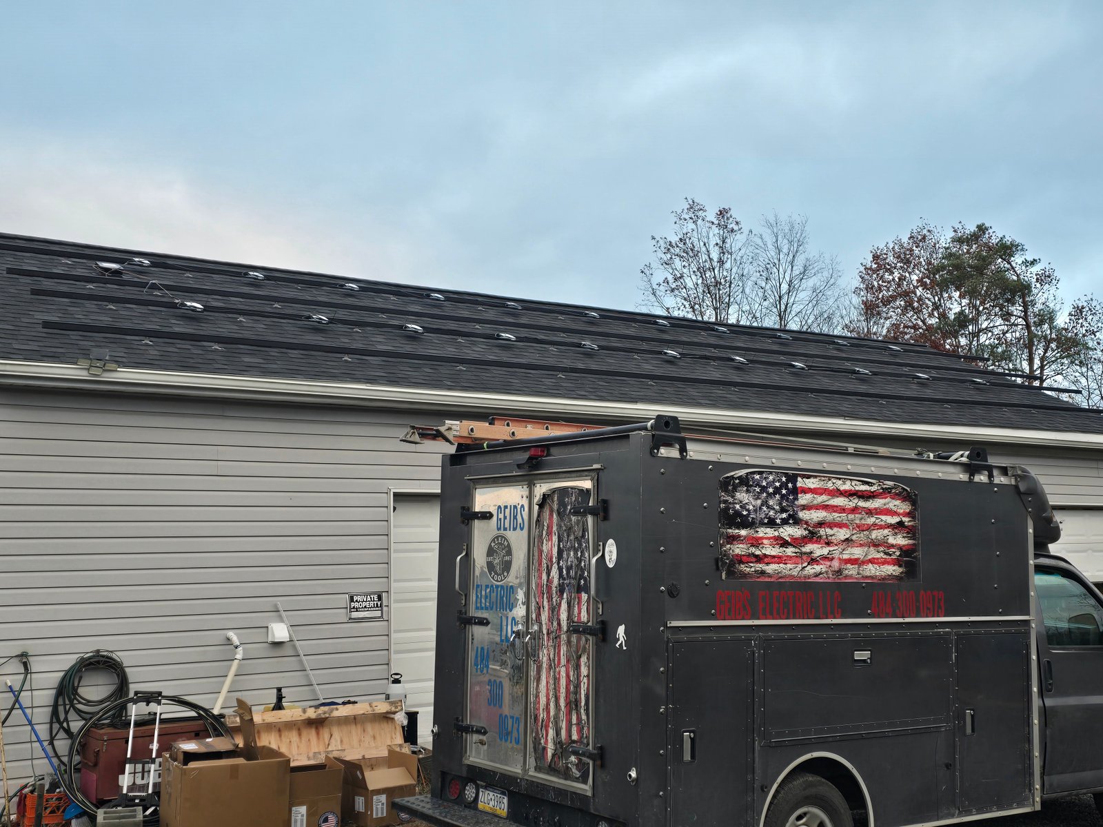 Geib's Electric service truck with American flag graphics at a job site